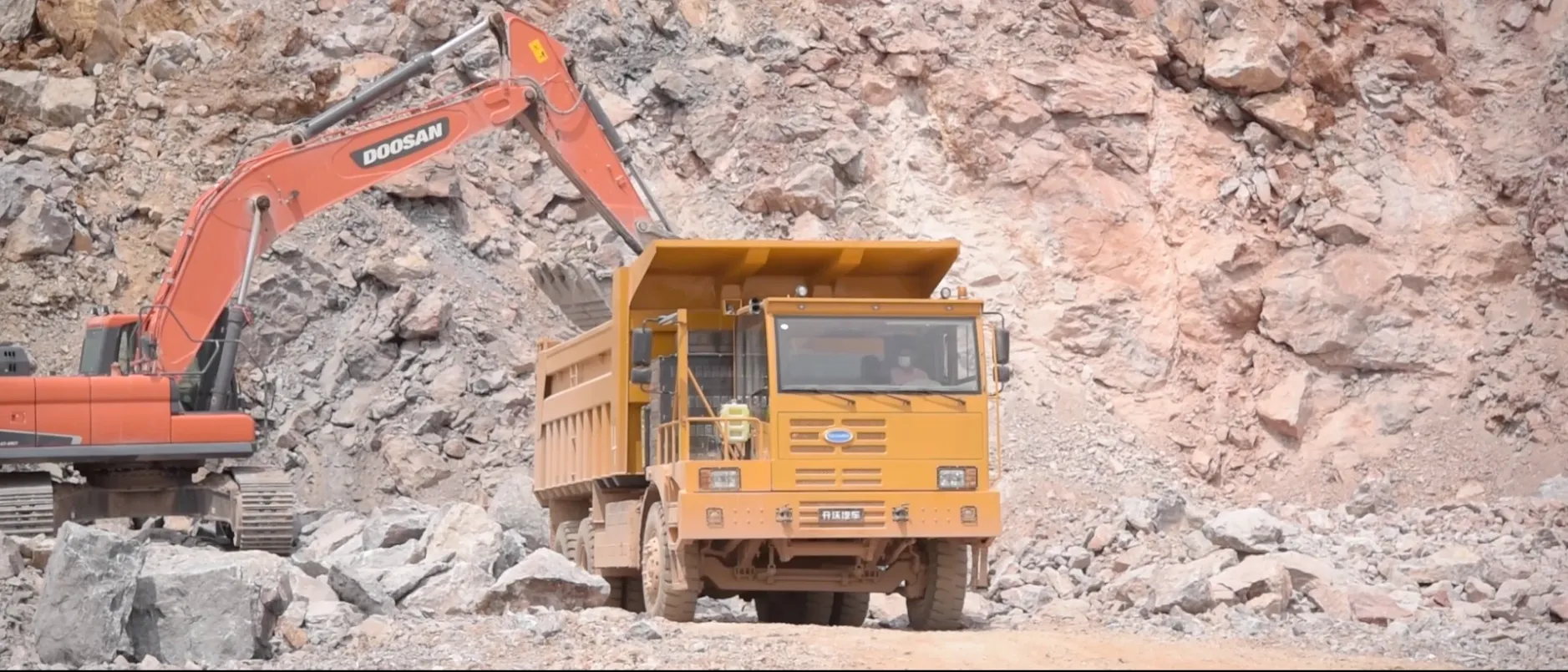 Excavator loading autonomous haul truck