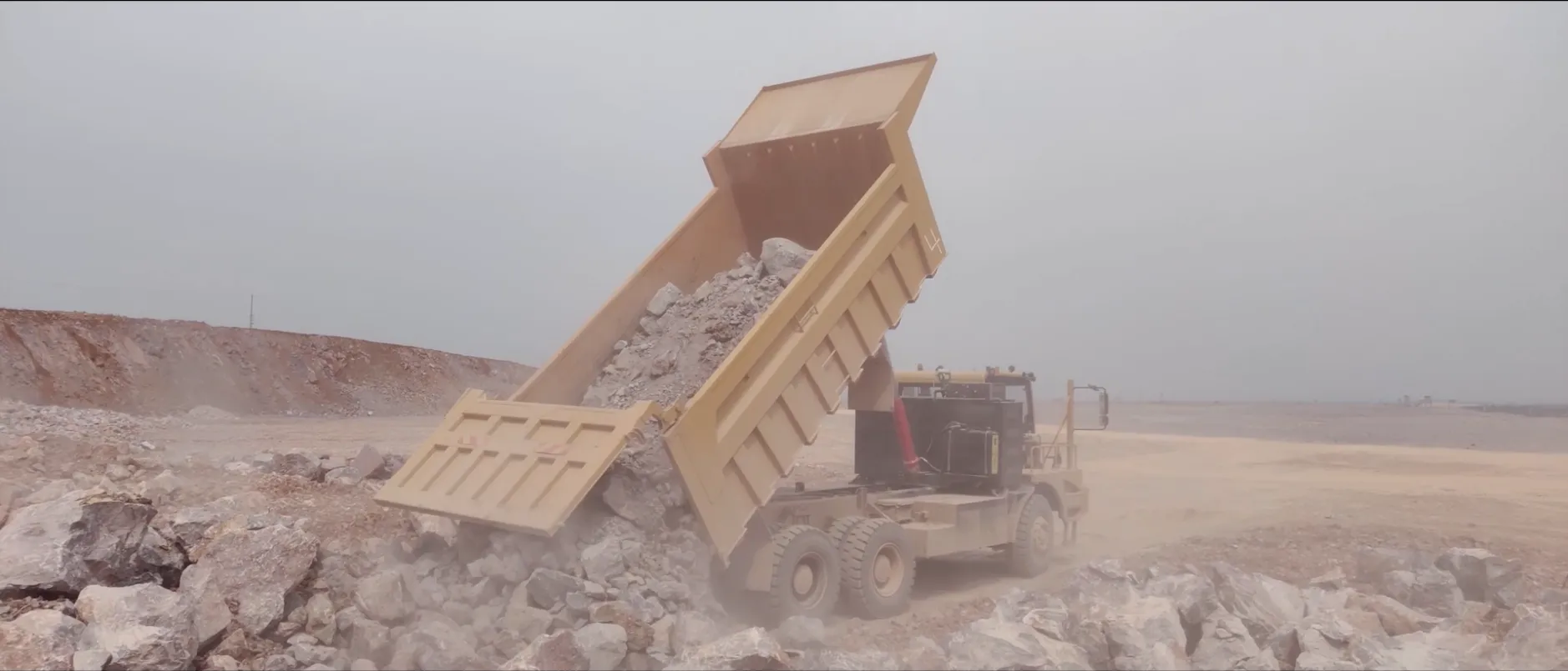 Mining truck unloading at dump site